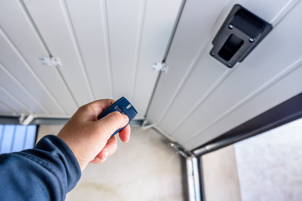 man opent garage met druk op knop